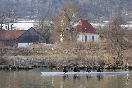 Ein Ruderboot auf dem Kanal vor der Wallfahrtskirche Griesstetten