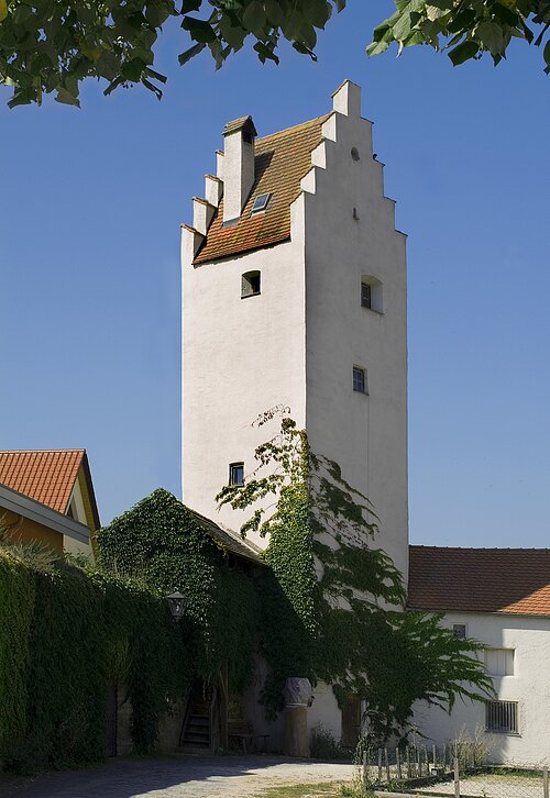Blick auf den Goggerturm von vorne mit bewachsener Stadtmauer links.