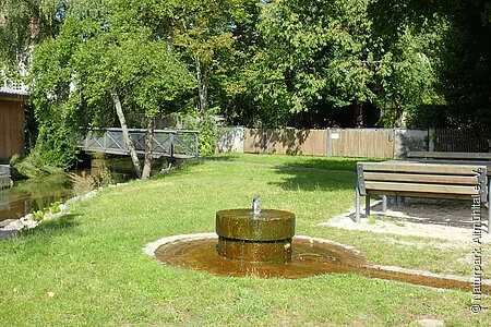 Brunnen am Mühlbach mit Sitzbänken