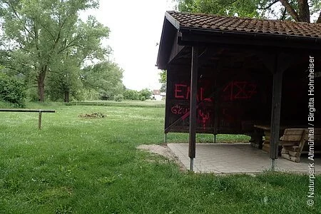 Eine Schutzhütte aus Holz mit Dach und einem befestigten Boden schützen die Bootswanderer bei Regen vor der Nässe.