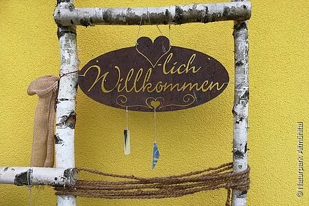 Willkommensschild mit Birkenastumrandung