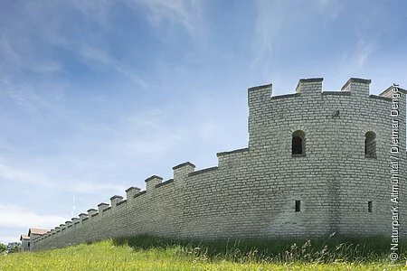 Das Römerkastell Vetoniana inmitten einer grünen Wiese. Das Kastell erstreckt sich nach hinten und man kann die Mauer mit ihren Zinnen gut erkennen.