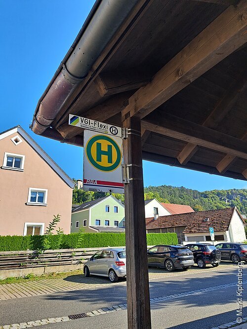 Bushaltestelle mit Vordach, im Hintergrund Fahrzeuge