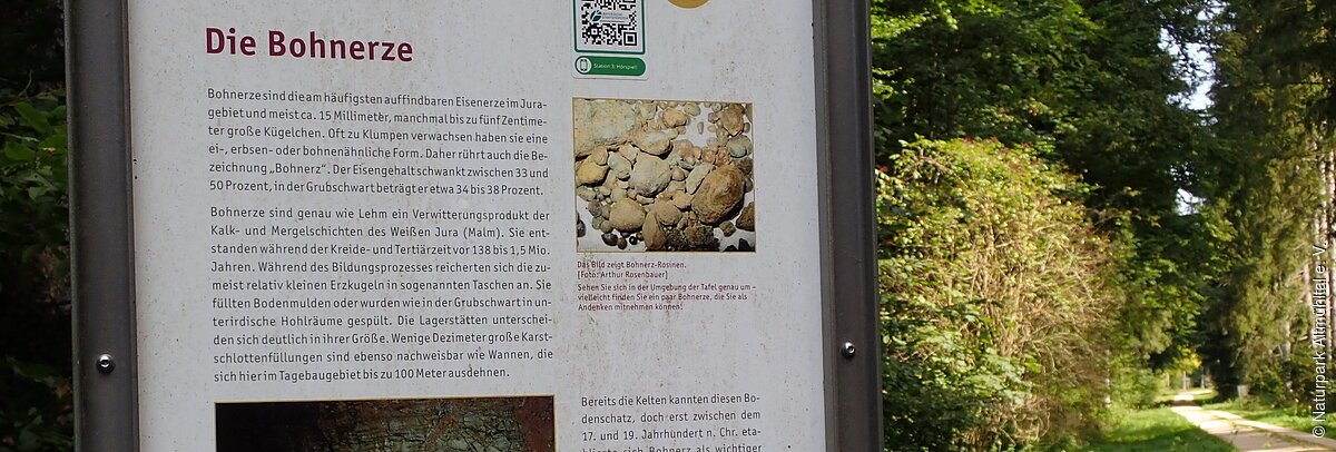 Informationstafel zum Thema Bohnerze ist am Wegesrand zu erkennen