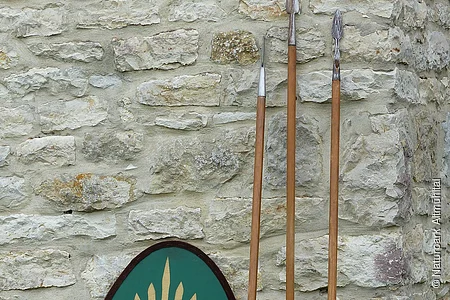 Die Nachbildungen eines römischen Schildes und dreier Pila lehnen an der rekonstruierten Toranlage des Kastell Pfünz. Beim Pilum handelt es sich um einen Wurfspeer, die typische Waffe römischer Legionäre.