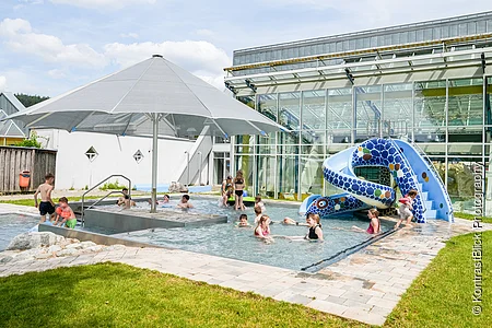 Außenbereich des Sport- und Freizeitbades Greding mit Planschbecken und Wasserrutsche