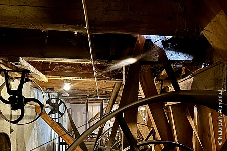 In dem dunklen Innenraum sind des Mühlenmuseums sind die Mühlräder zu sehen