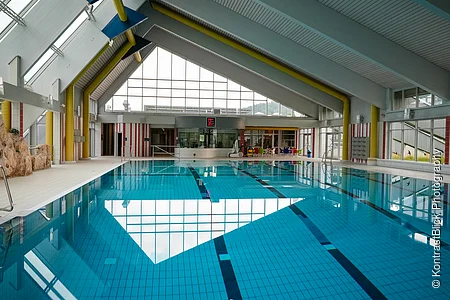 Innenansicht des Gredinger Hallenbads mit großen Fenstern und blauen Fliesen im Beckenboden