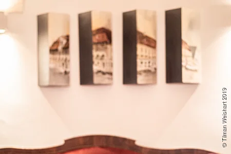 Ein Sofa der Post Berching mit im Hintergrund die Post Berching als einzelne Bildstücke an der Wand.