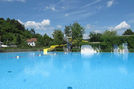 Schwimmbecken mit Rutsche im Hintergrund