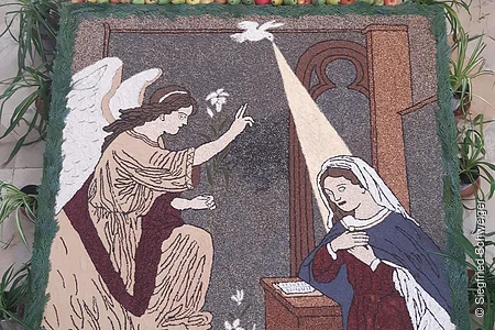 Das Körnerbild "Maria Verkündigung" zeigt wie der Engel Gabriel Maria erscheint. Es ist aus verschiedenen Körner in unterschiedlichen Farben "gemalt".