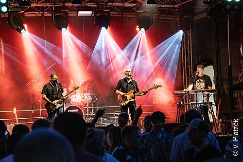 PLATZfest 2026 - Band Midlife Crisis Ltd. Die Stimmung wird ausgelassen, locker und fröhlich sein – die Berchinger bleiben sich treu. 2027 geht das PLATZfest in die sechste Runde.
Das PLATZfest findet inmitten der Altstadt statt und bietet Musik mit Konzertcharakter. Die Musik spielt auf der großen Bühne in der Nähe des Zunftbaums. Berchinger Vereine, Wirte und weitere Verkaufsstände sorgen für das leibliche Wohl.
MIDLIFE CRISIS LTD, die renommierte Oldie-Band, wird für beste musikalische Stimmung sorgen. Die sympathische 4-köpfige Gruppe spielt “absolut live” das Beste aus den 60er, 70er, 80er und 90er Jahren. Songs u. a. von den Beatles, Rolling Stones, Creedence Clearwater Revival, Monkees, Beach Boys, Thin Lizzy, John Miles, Status Quo, Eric Clapton, Jethro Tull, T.Rex, Deep Purple, uvm.
17:30 Uhr: Essensstände öffnen
18:30 Uhr: Hechtonia Teenie-Showtanz-Mix (vor der Bühne am Reichenauplatz)
19:00 Uhr: Stadtkapelle Berching (im Hans-Kuffer-Park)
19:30 Uhr: Midlife Crisis Ltd spielen auf der Bühne am Reichenauplatz
(Änderungen im Programm vorbehalten)